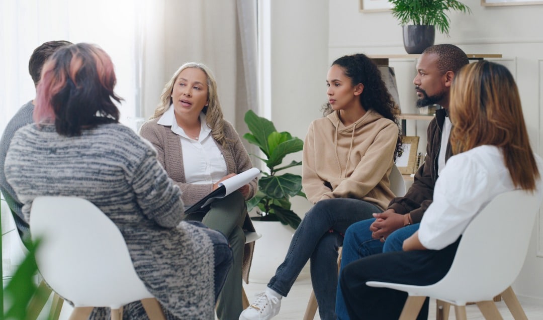 A group of people participating in a group therapy session.
